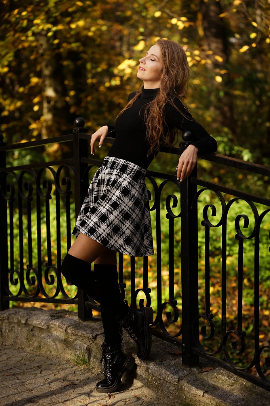 Kasia by a park railing in autumn